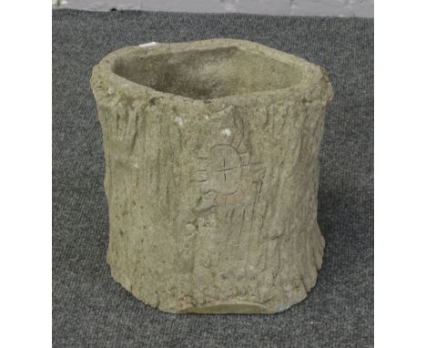 A concrete planter in the form of a tree trunk.