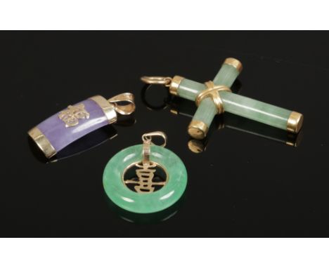 A gold mounted jade crucifix pendant and two 9ct gold mounted Chinese jade pendants ornamented with Shou characters, one lave