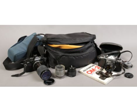 An Olympus OM-2 SLR 35mm camera with manual along with a Pentax Asahi SLR 35mm camera and accessories.