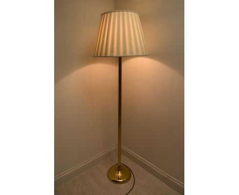 A brass plated standard lamp with shade raised on  circular foot. H.164.5 Shade Dia. 50cm 