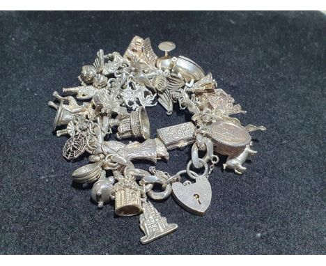 A silver bracelet with 925 and white metal charms (myth and magic themed). Weight 133.74g 