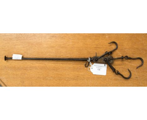 A late 17th or early 18th Century iron beam scale with various suspension and weighing hooks, cast iron foundry stamp