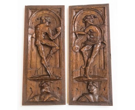 A pair of late 16th Century carved athletes, naked and standing on plinths in arcaded niches with a portrait below, probably 