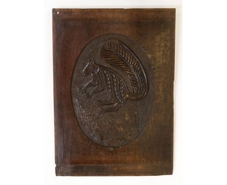 A rare late 17th or early 18th Century carved oak panel of an English red squirrel in an oval portrait, recessed matted groun