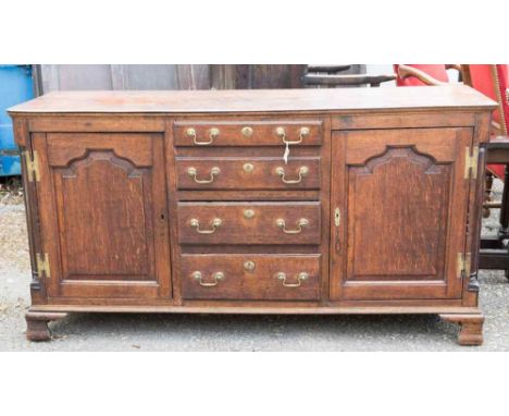 A George III oak dresser base, circa 1770, possibly attributed to Lancashire, fitted with two doors and four graduated drawer