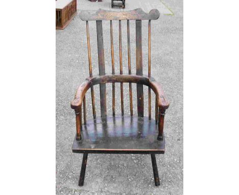 A George III elm Windsor comb-back armchair, possibly Welsh, the back with a shaped crest rail, solid seat and raised on turn