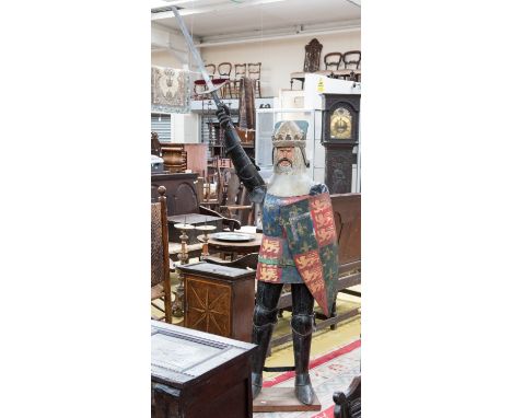 An early 20th century painted metal model figure of a knight, modelled standing holding a shield and with sword raised, heigh