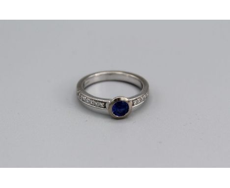 A Tanzanite and diamond ring in white 18ct gold, rub over setting, size N. Gross weight approx 5.1gm, est diamond weight 0.14