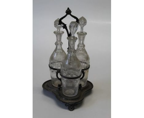 A silver plated decanter stand with three bottles and stoppers in a trefoil shaped frame, h46cm