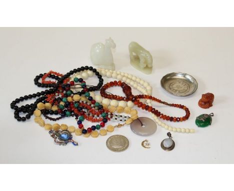 A small mixed lot of simulated amber, coral and bead necklaces, tourist ware jade figures, commemorative Chinese coin-set dis