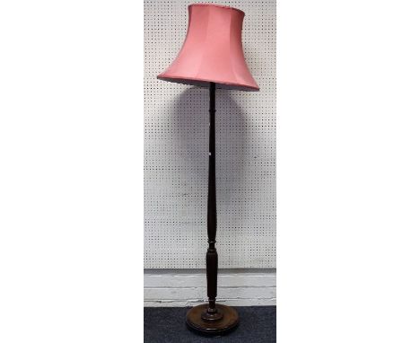 A 1920's oak standard lamp with salmon fabric shade, turned and reeded column on dished circular base, 175cm