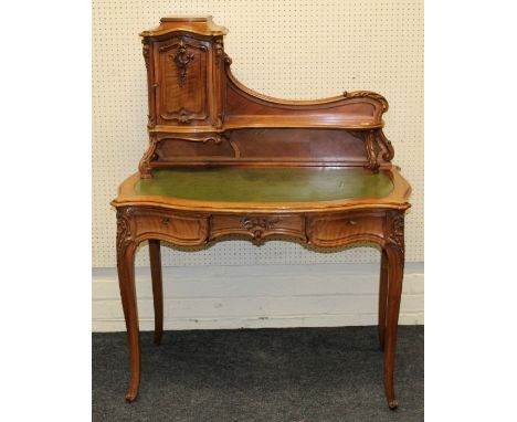 Dress et Fils, Paris, an early 20th century French walnut lady's bureau plat, the swept cupboard and shelf upstand over serpe