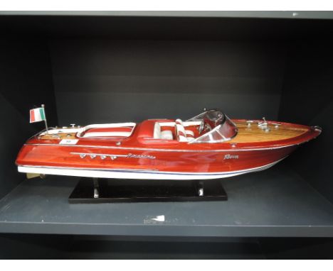 A scale model of an Italian Riva motor boat, with wooden hull, leather interior, on standLength 27 inchesWidth 8.5 inchesHeig