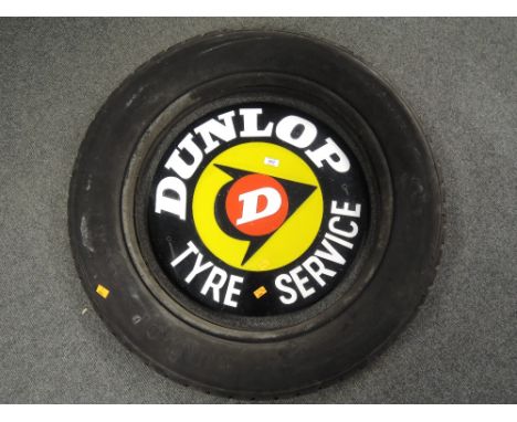 An acrylic circular sign for Dunlop tyre service housed with an original 1930's Dunlop Cord truck tyre