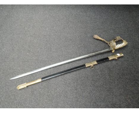 A British Naval officers sword with brass lion head pommel, engraved blade, leather and brass scabbard, possibly Victorian