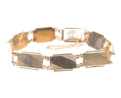 A 9ct gold panel bracelet, circa 1930sEach rectangular panel, with engine turned decoration and link connectors, attached saf