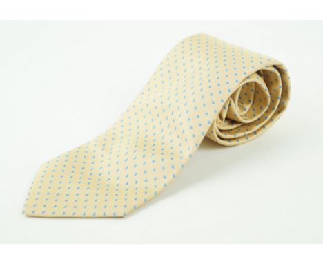 An Hermes silk tieThe pale yellow ground with a light blue polka dot repeating pattern, 144cm