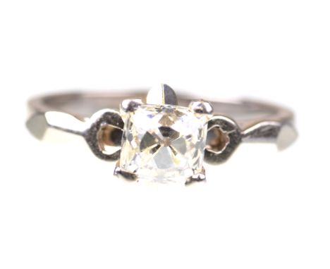 A diamond single stone ringThe old-cut cushion diamond, four claw set, to a raised stylised white metal mount and shank stamp