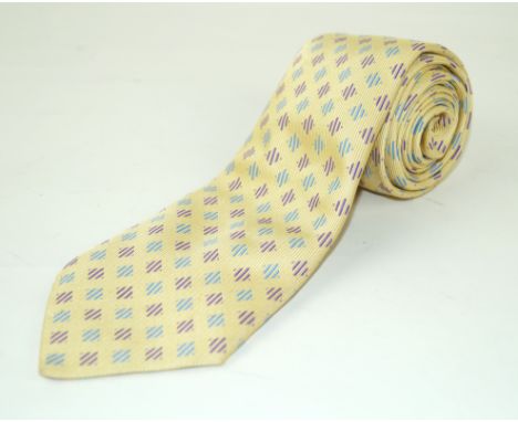 An Hermes silk tieWith a woven pale blue and purple lozenge design, against a pale yellow ground, length 149cm 