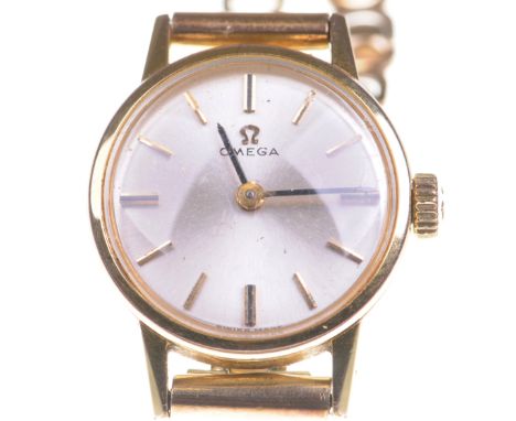 Omega: A ladies 9ct gold manual wind bracelet watchThe silver tone dial of circular form, with applied hourly baton markers, 