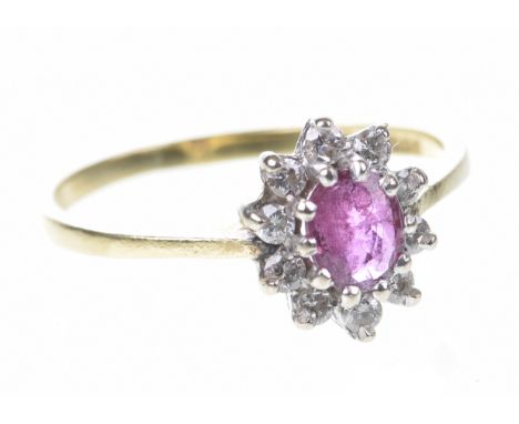 A ruby and diamond cluster ring The oval-shaped ruby to a round brilliant-cut diamond surround, to an 18ct gold shank, ring s