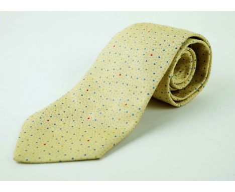 An Hermes silk tieThe woven pale yellow ground, with blue speckled detail and spots of blue, green and ochre, length 149cm