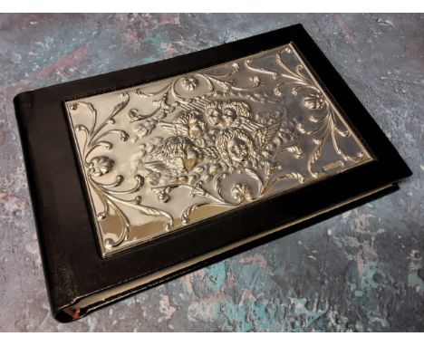 A silver mounted black leather guest book, the silver panel embossed in relief with Reynolds Angels, Ron Carr, Sheffield, 199