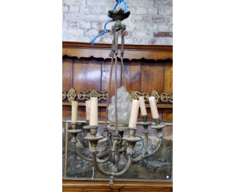 A French gilt metal chandelier with central frosted glass torch / flame finial, showing signs of age, later converted to elec