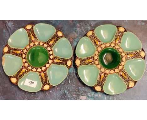A pair of Minton majolica oyster dishes, moulded with a central circular well radiating six triangular sections divided by sh