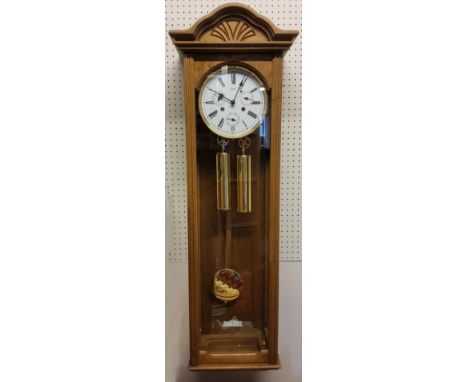 A Hermle oak finish regulator wall clock with 1/2 hour strike, 8 day cable driven movement, white enamel dial, black Roman nu