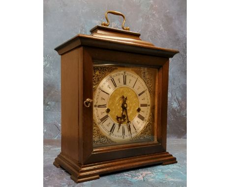 A 20th century mahogany bracket clock, Indian mask foliate scroll spandrels, Roman numerals, three winding holes, German move