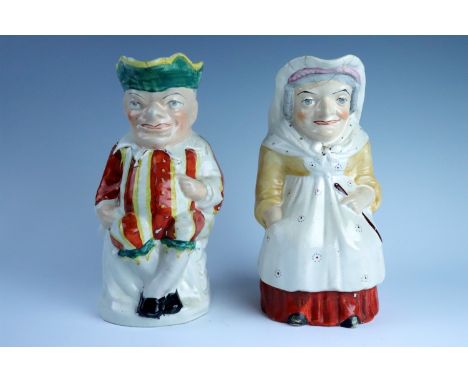 A pair of 19th Century Staffordshire earthenware Punch and Judy character jugs, having polychrome enamel decoration, both rep