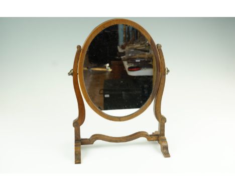 A 19th Century mahogany oval swivel toilet mirror, 27 cm x 37 cm