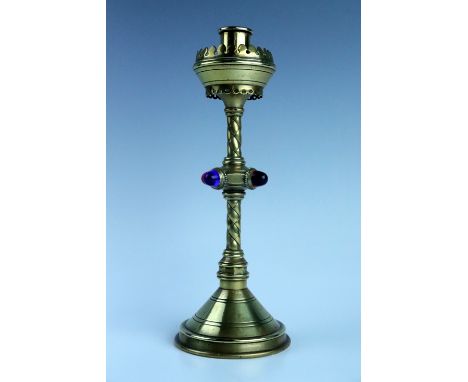 A Victorian gothic revival ecclesiastical brass candle stick, its stem having a collar with applied glass cabochons, 27.5 cm 