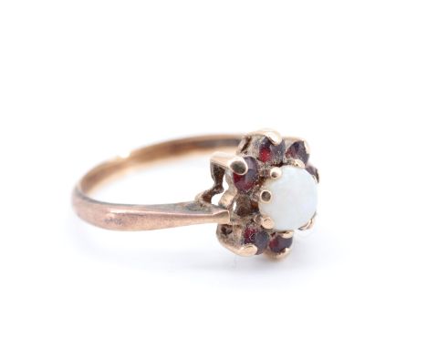 An opal and garnet flowerhead cluster ring, the opal cabochon of 5 mm diameter, set on 9 ct gold, M, 2 g, (a/f)