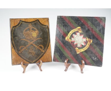 A wooden plaque painted in regimental colours and bearing an affixed Victorian 10th Battalion Black Watch cap badge, together