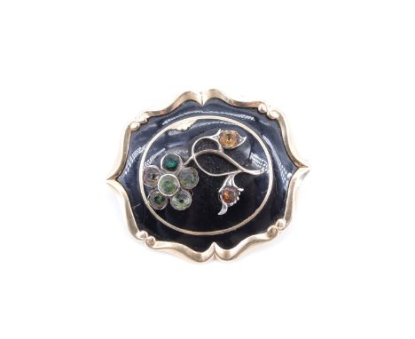 A Victorian yellow metal and enamel mourning brooch, having a raised flower set with pastes, on a black enamel field within a
