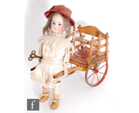 A late 19th Century French Roullet et Decamps girl pulling a cart automaton, circa 1890, the Limoges bisque socket head with 