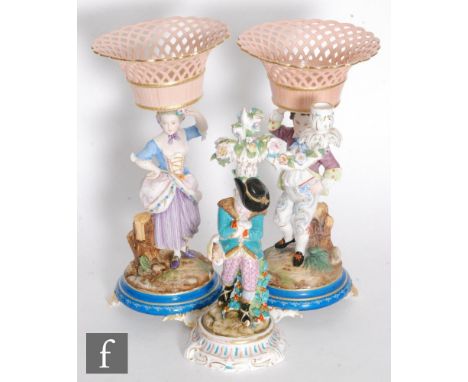 A pair of early 20th Century continental bisque pedestal comports modelled as a young girl and boy stood beside a tree stump 