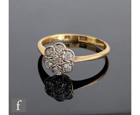 An early 20th Century 18ct diamond daisy cluster ring, seven stones to knife edged shoulders, weight 1.8g, ring size K. 