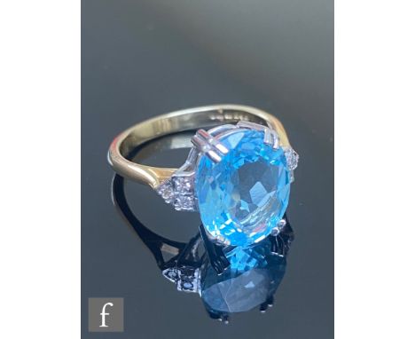 An 18ct hallmarked blue topaz and diamond ring, central oval claw set topaz, length 12mm, flanked by three diamonds to each s