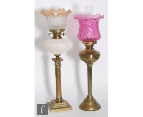 A Victorian style brass oil lamp and shade and a similar lamp with part white and amber shade, one lacking chimney. (2) 