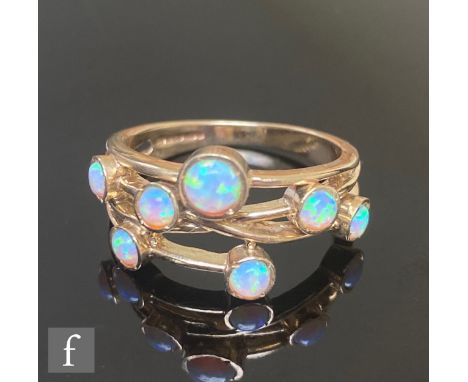 A 9ct hallmarked opal ring with seven individually set stones in the manner of Boodles, weight 3.6g, ring size M. 