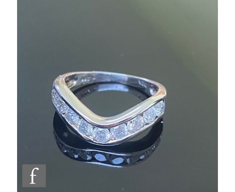 A 9ct diamond half eternity ring comprising nine channel set brilliant cut diamond to a shallow wishbone shaped head, weight 
