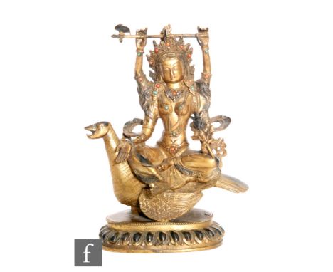 A Sino-Tibetan figure of Avalokitesvara, cast seated on bird, holding a ritual axe aloft, and further holding attributes and 