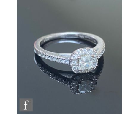 An 18ct hallmarked white gold diamond ring, central princess cut stone within a diamond set cushioned rectangular head and fu