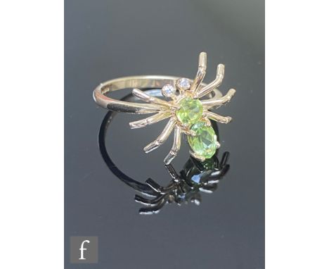 A 9ct hallmarked peridot and diamond spider shaped ring, the two peridot body below diamond set eyes, width of head 15mm, wei