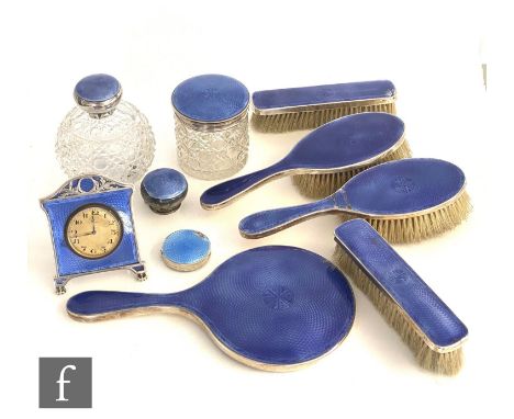 A hallmarked silver and blue enamel dressing table set to include four brushes, a hand mirror and easel clock, a scent bottle