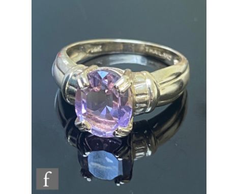 A modern 14ct single stone amethyst ring, oval claw set stone to reeded shoulders, weight 4g, ring size N. 