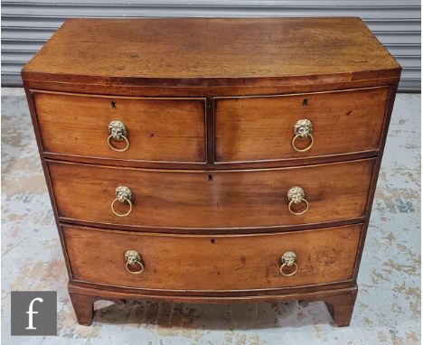 A small George III mahogany bowfront chest of two short and two long drawers, lion brass drop handles, on shaped bracket feet